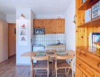 a kitchen with wooden cabinets and a dining room table